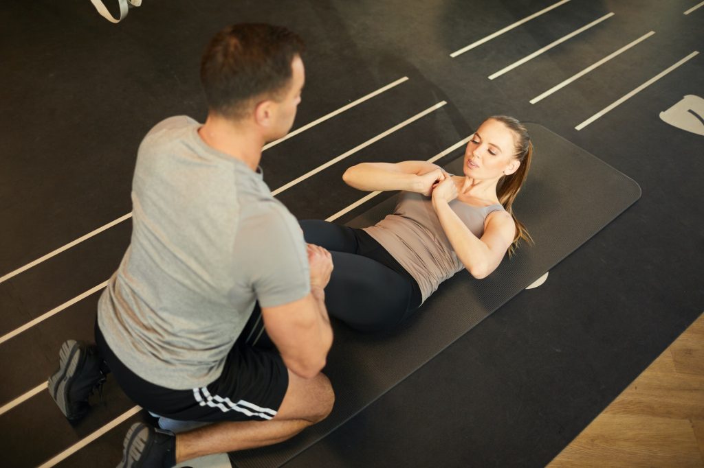Fitness Coach Working with Woman in Gym